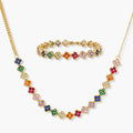 Colorful four-leaf clover jewelry set with rainbow cubic zirconia stones in gold-plated setting on white background