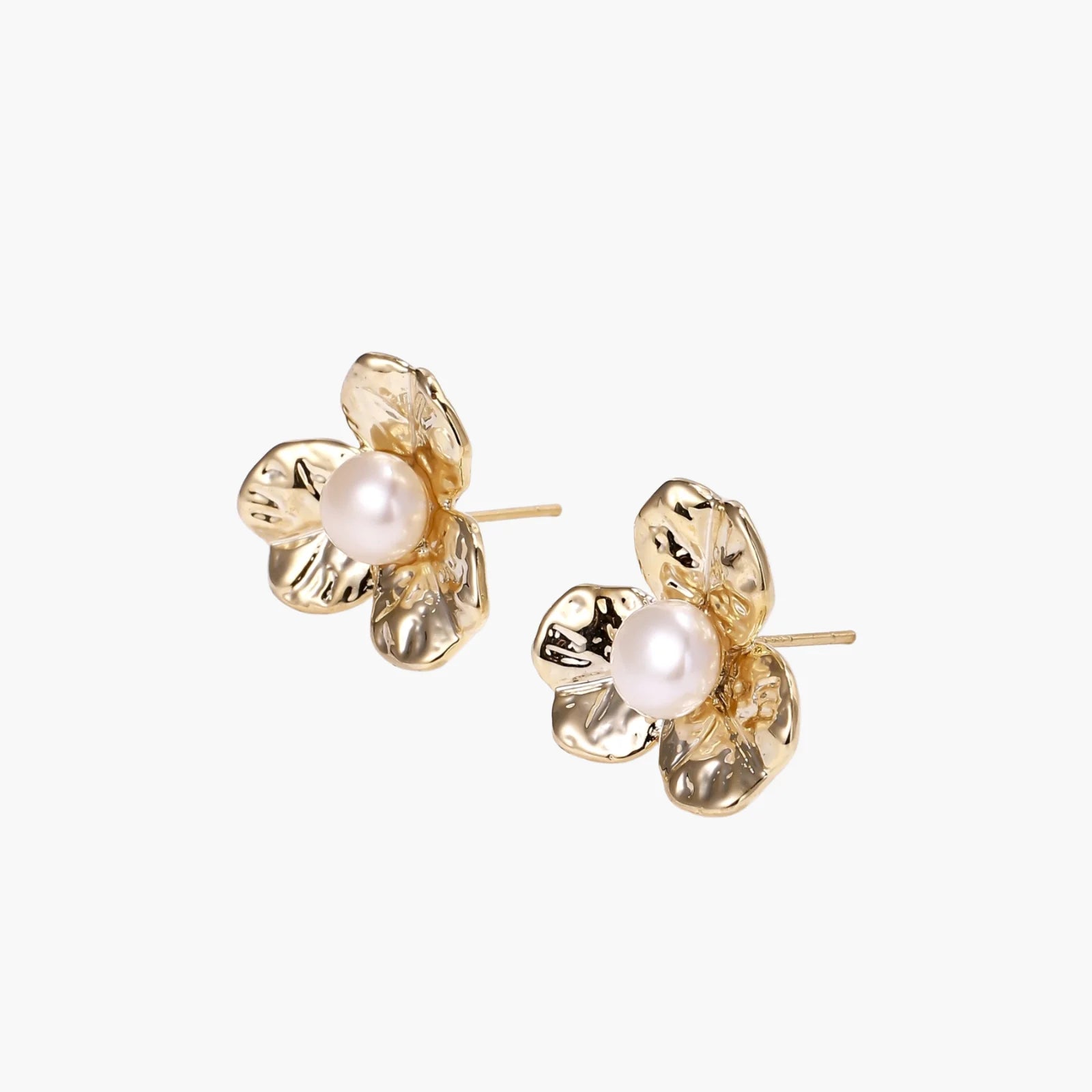 Gold-plated flower stud earrings with textured petals and centered freshwater pearl on beige background