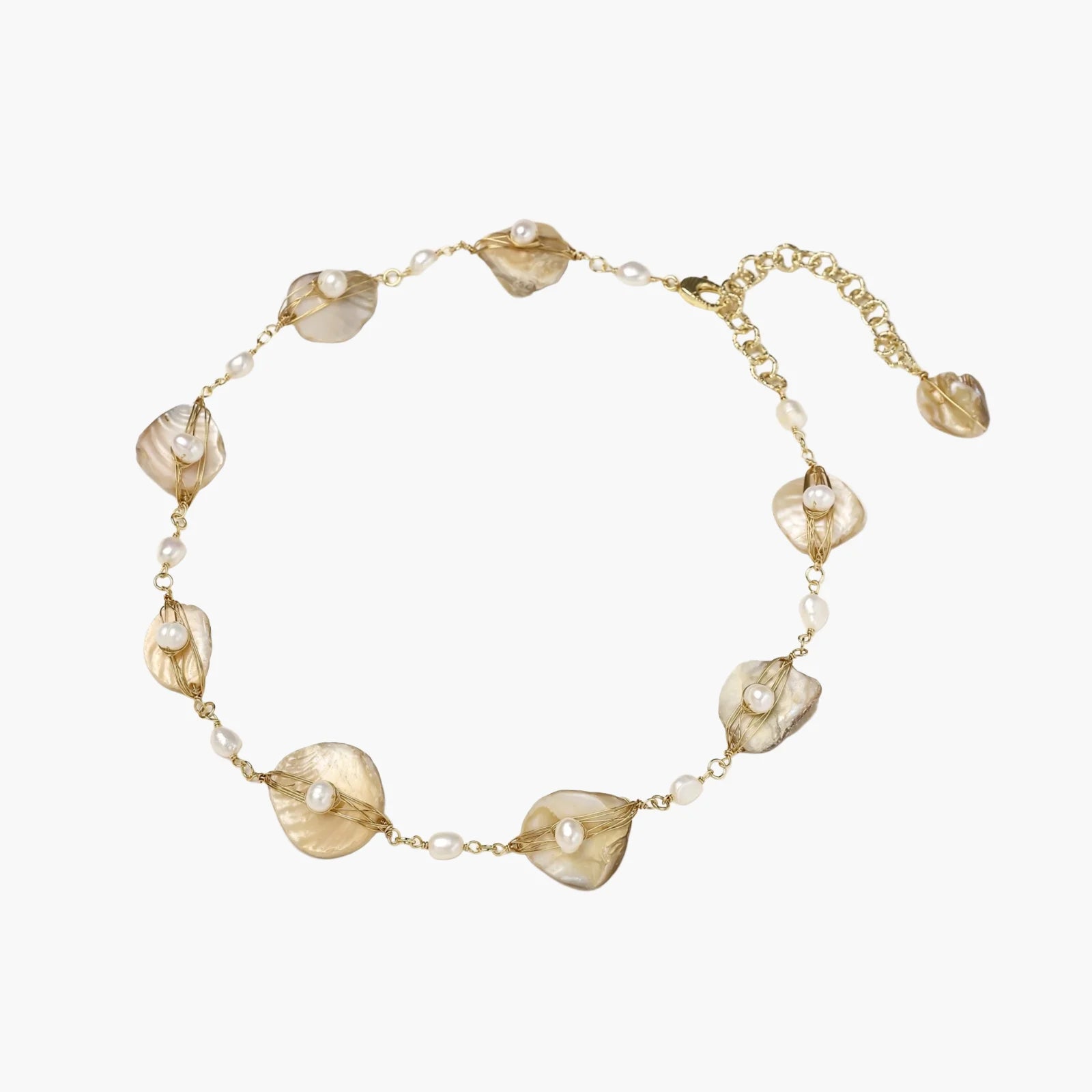Gold-plated necklace with wire-wrapped shell pieces and freshwater pearls on neutral background, adjustable chain visible.