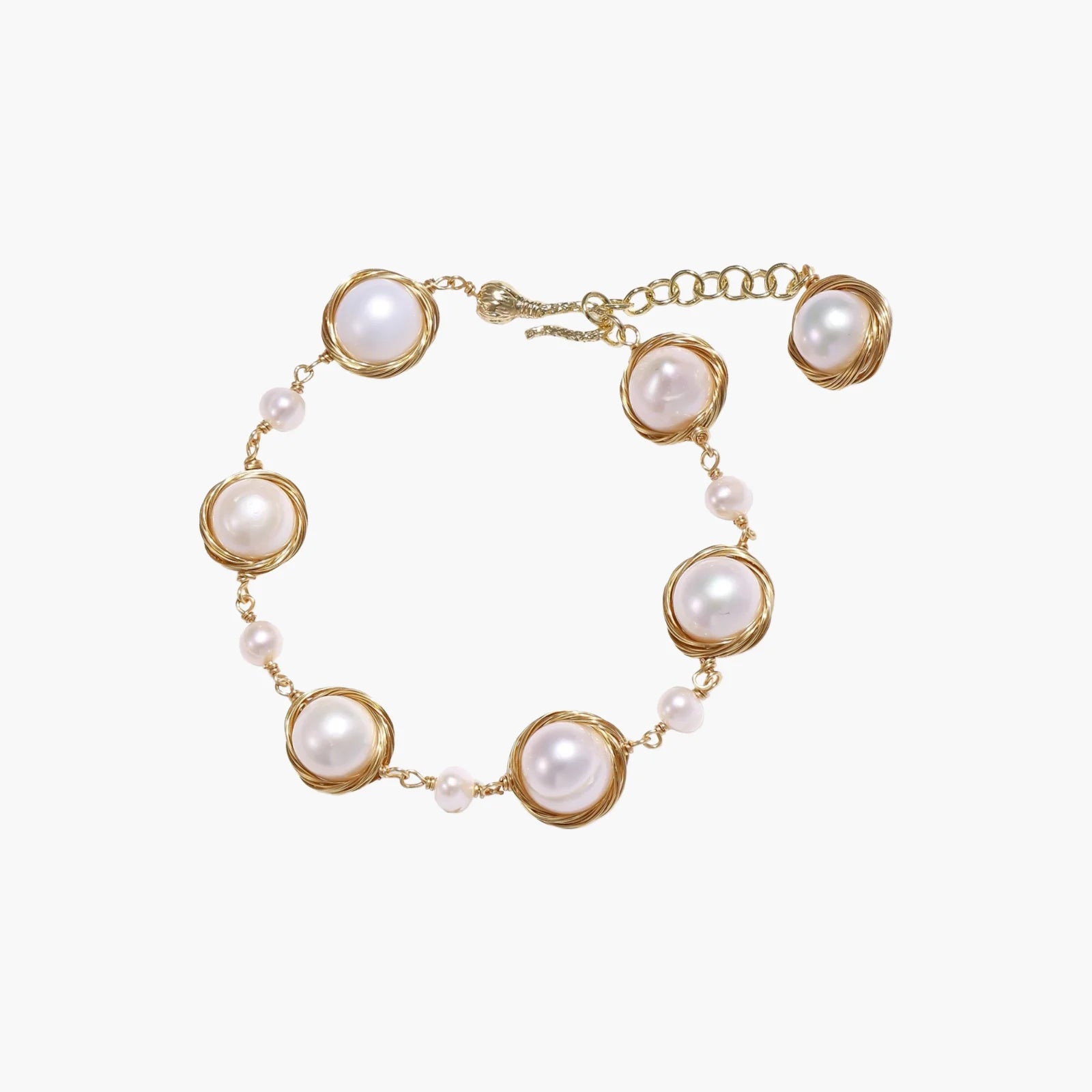 Gold wire-wrapped freshwater pearl bracelet with alternating pearl sizes on cream background, adjustable length