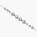 Sterling silver bracelet with graduated heart-shaped links and sparkling moissanite stones in VVS1 clarity on white background.