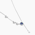 Delicate sterling silver necklace with crystal-set butterfly charms and rainbow moissanite pendant on white background.