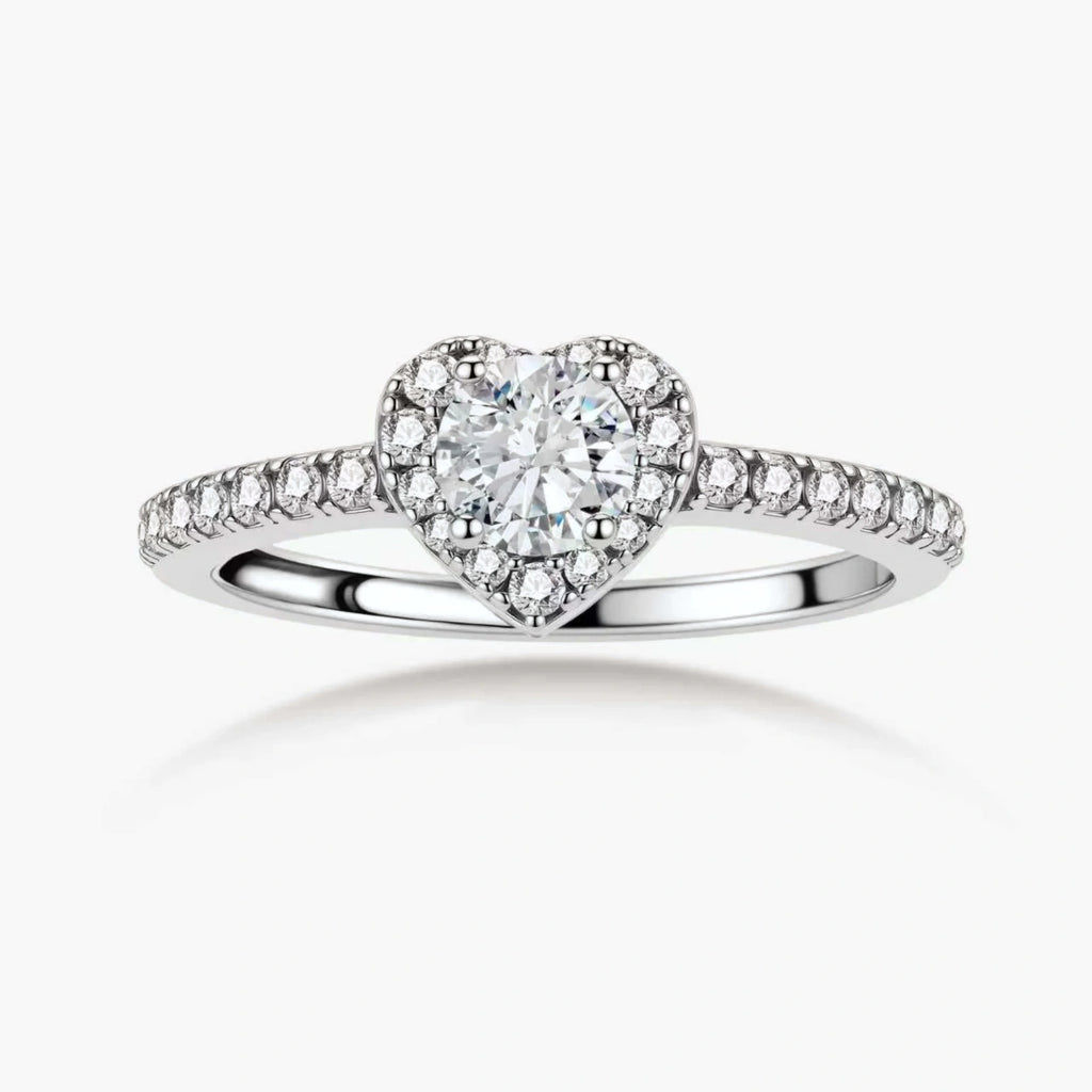 Heart-shaped halo ring with brilliant moissanite center stone surrounded by smaller crystals in sterling silver setting