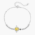 Sterling silver bracelet with yellow moissanite centerpiece in oval setting, crystal chain, and star charm on white background.