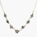 Adjustable cream cord necklace with white spotted stone beads featuring black speckles on neutral background