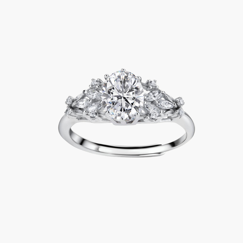 Sterling silver ring with oval moissanite center stone surrounded by smaller accent stones in ornate setting