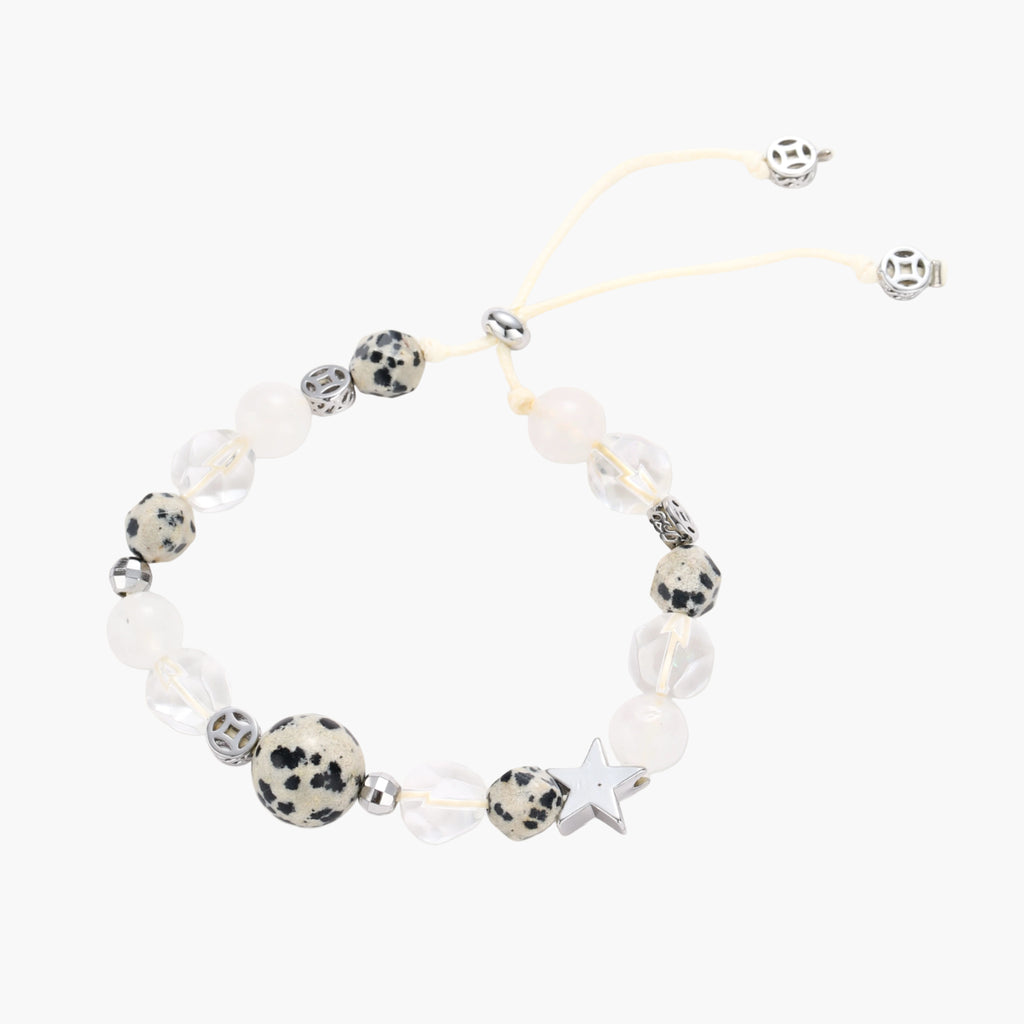 Adjustable beaded bracelet with spotted dalmatian stones, clear quartz crystals, and silver star charm on white background.