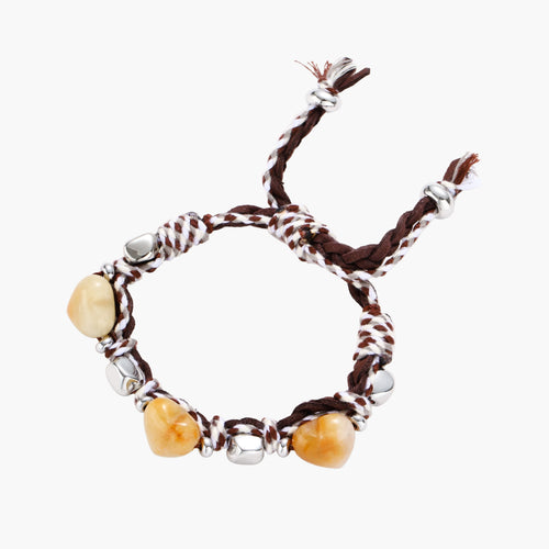 Braided brown and cream suede cord bracelet with heart-shaped amber gemstones and brass beads on white background.