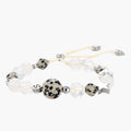 Adjustable beaded bracelet with spotted dalmatian stones, clear quartz crystals, and silver star charm on white background.