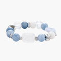 Stretchable bracelet with blue aquamarine beads, clear quartz crystals and copper accents on white background.