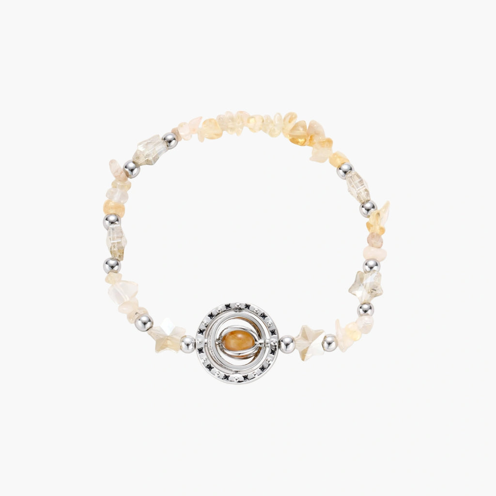Stretchable bracelet with cream citrine stone chips, brass beads, and central amber zirconia pendant on neutral background.