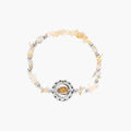 Stretchable bracelet with cream citrine stone chips, brass beads, and central amber zirconia pendant on neutral background.