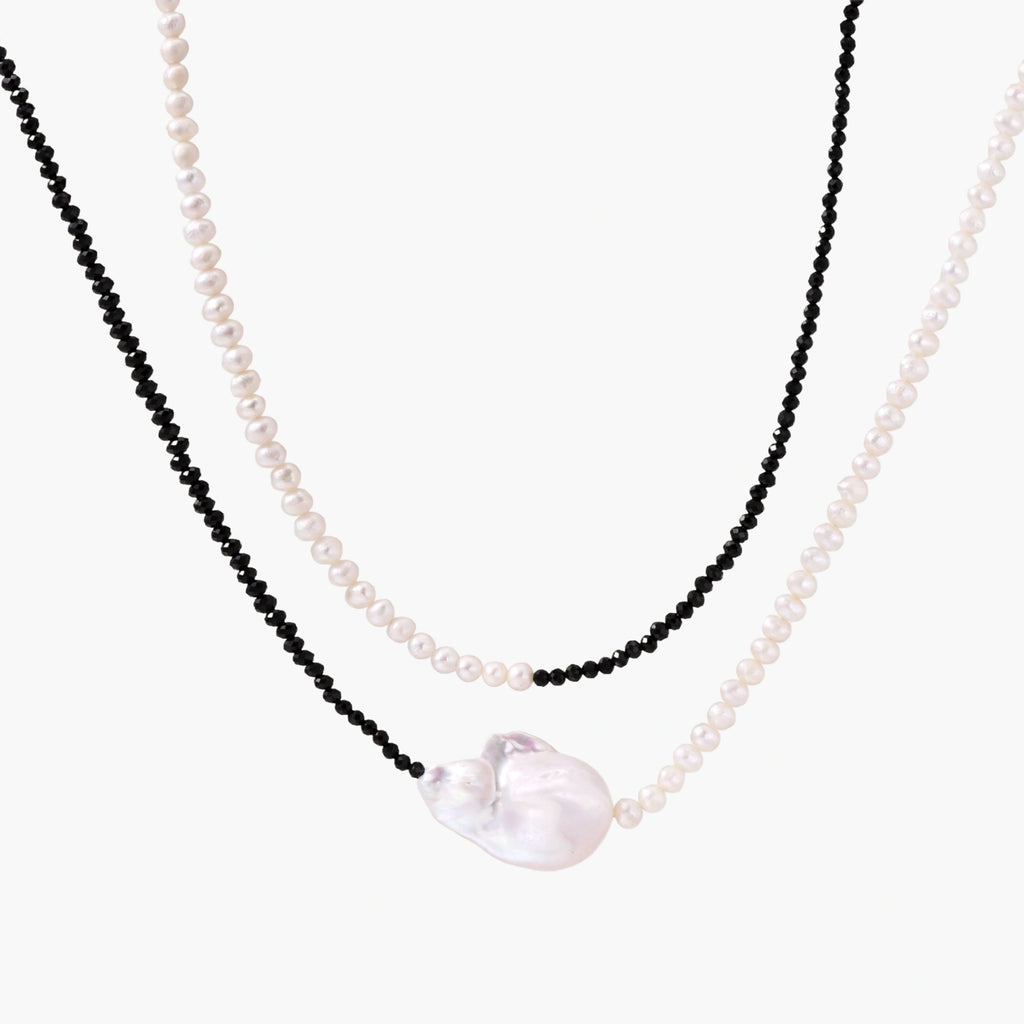 Double-strand necklace with black faceted quartz and white pearls featuring an oversized baroque pearl centerpiece