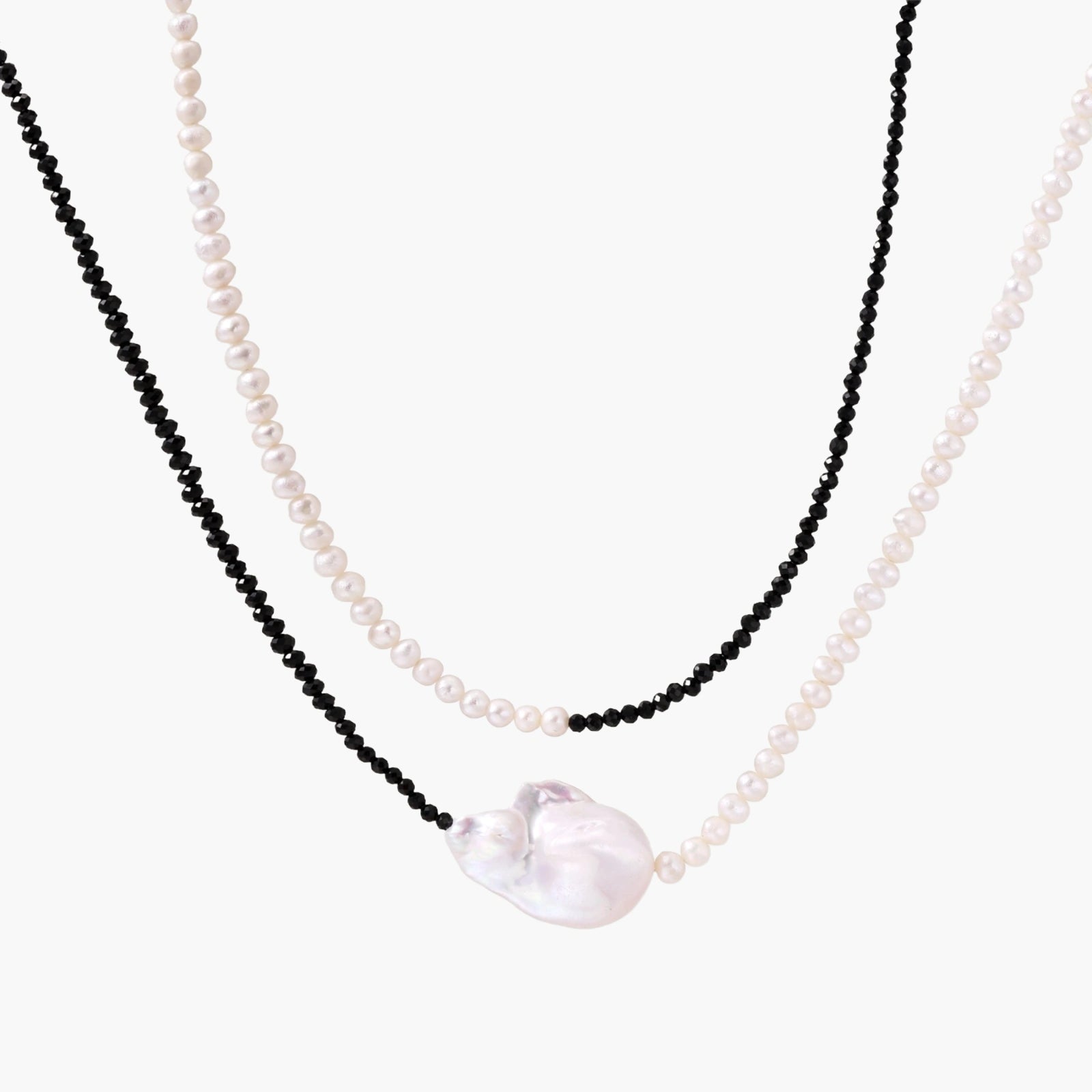 Double-strand necklace with black faceted quartz and white pearls featuring an oversized baroque pearl centerpiece