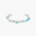 Delicate wire-wrapped bracelet featuring turquoise, rose quartz, freshwater pearls, and zircon on a white background.