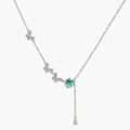 Sterling silver necklace with butterfly charms, green moissanite center stone, and teardrop crystal pendant on white background.