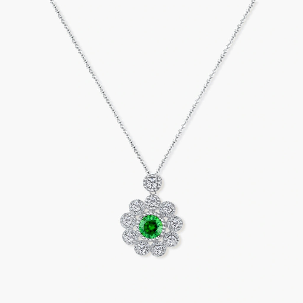 Delicate sterling silver necklace with flower-shaped pendant featuring bright green center moissanite and clear accent stones