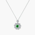 Delicate sterling silver necklace with flower-shaped pendant featuring bright green center moissanite and clear accent stones