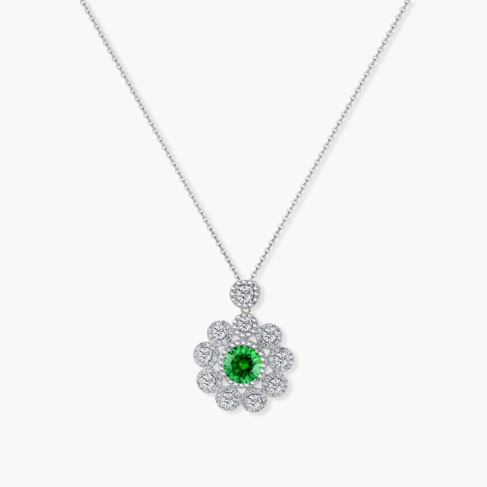 Delicate sterling silver necklace with flower-shaped pendant featuring bright green center moissanite and clear accent stones