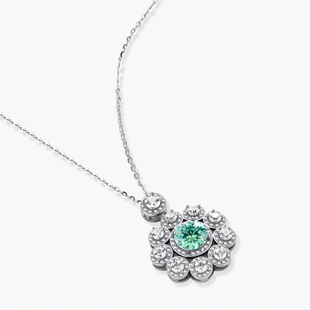 Delicate sterling silver necklace with flower-shaped pendant featuring bright green center moissanite and clear accent stones