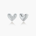 Pair of brushed platinum-plated 925 sterling silver puffy heart stud earrings on a cream background.