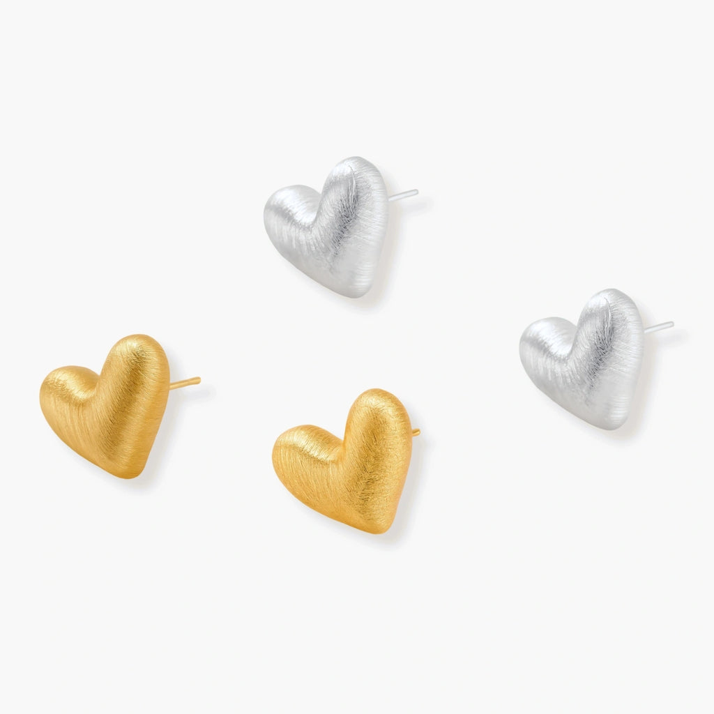 Pair of brushed platinum-plated 925 sterling silver puffy heart stud earrings on a cream background.