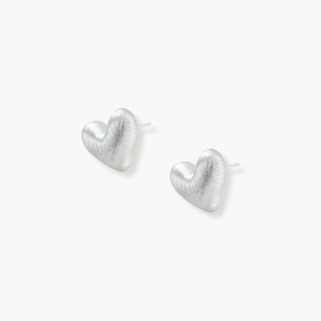 Pair of brushed platinum-plated 925 sterling silver puffy heart stud earrings on a cream background.