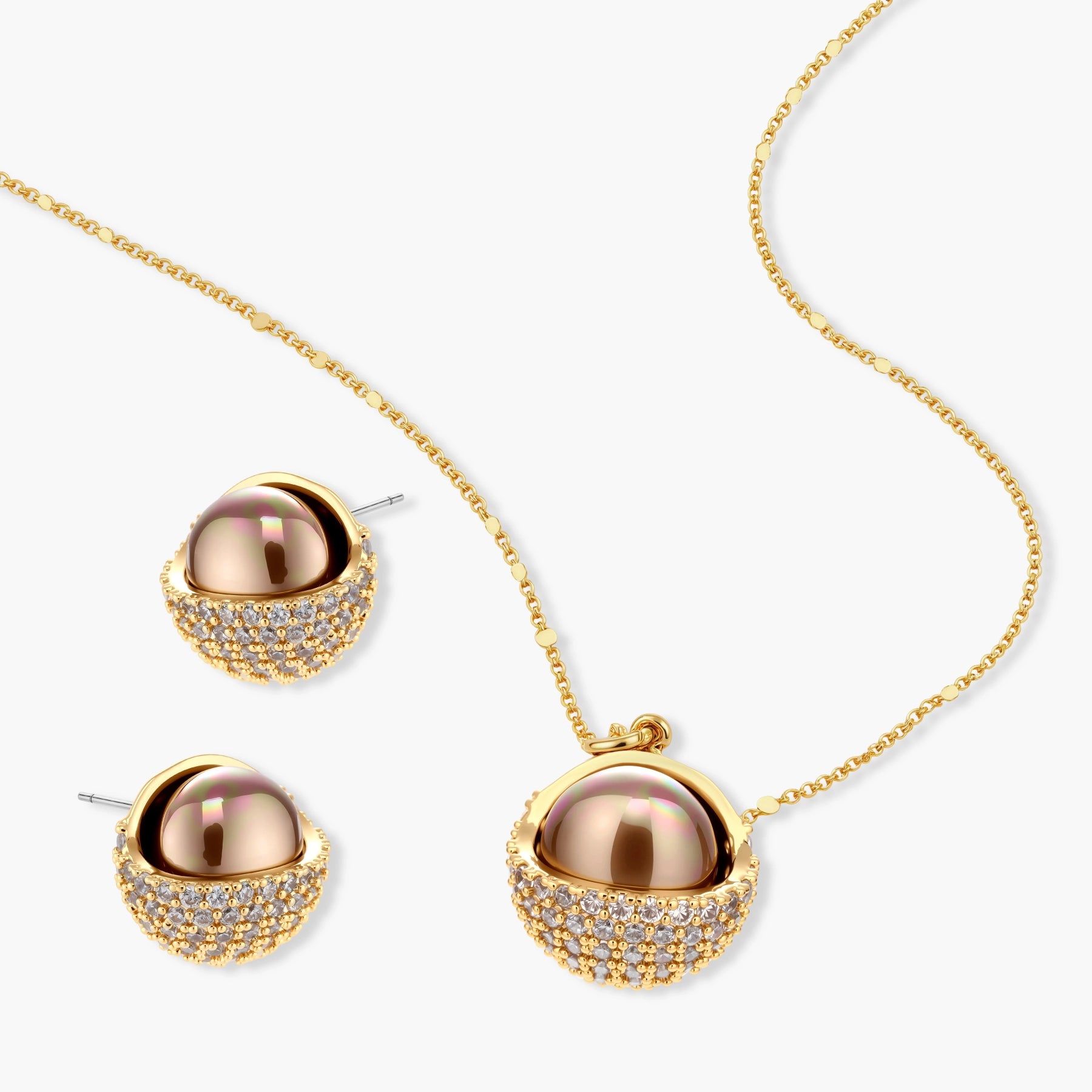 Elegant spherical pendant necklace and earrings set featuring crystal-pavé bottom half in gold or silver finish on white background.
