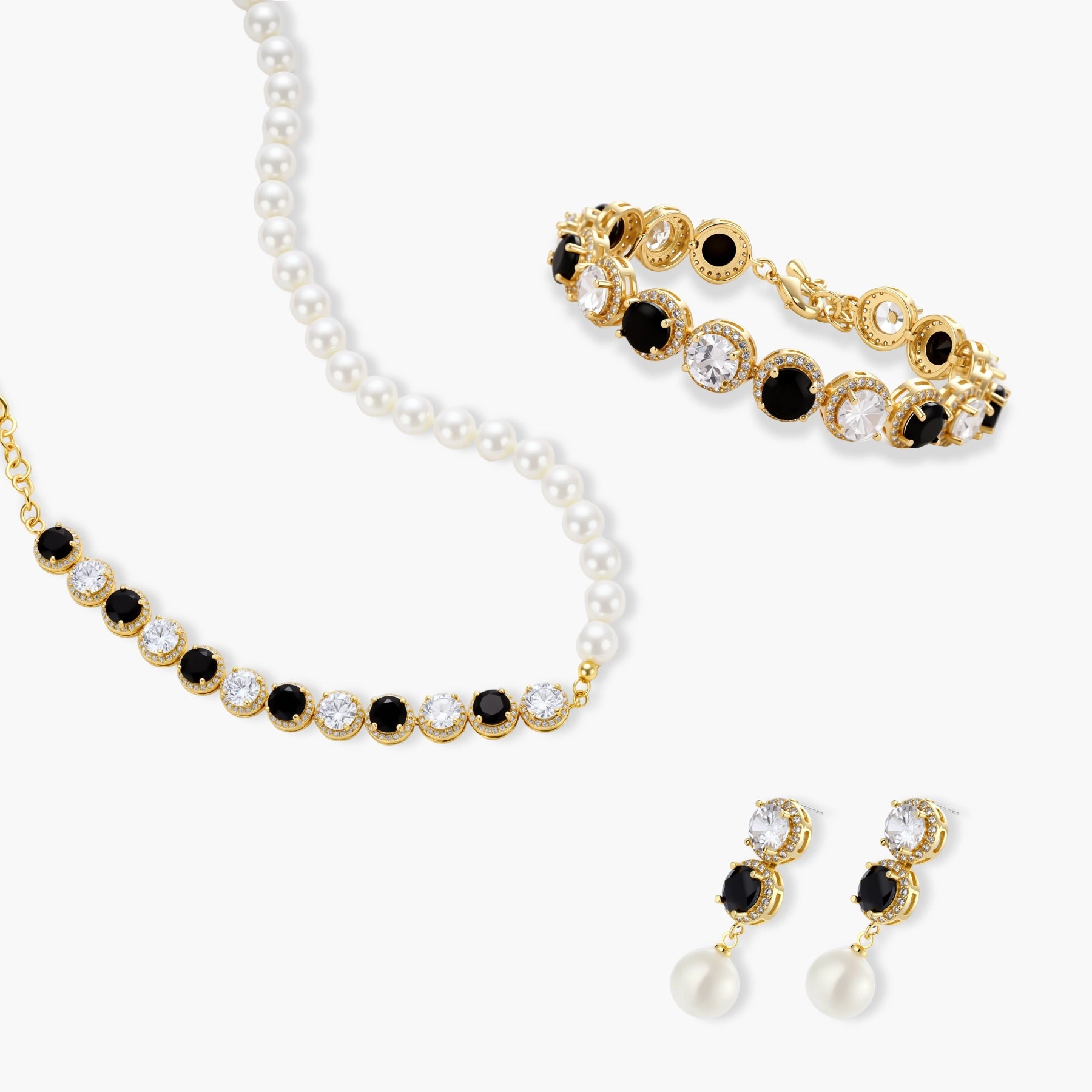 Gold-plated jewelry set with alternating black and clear cubic zirconia stones, featuring necklace, earrings and bracelet