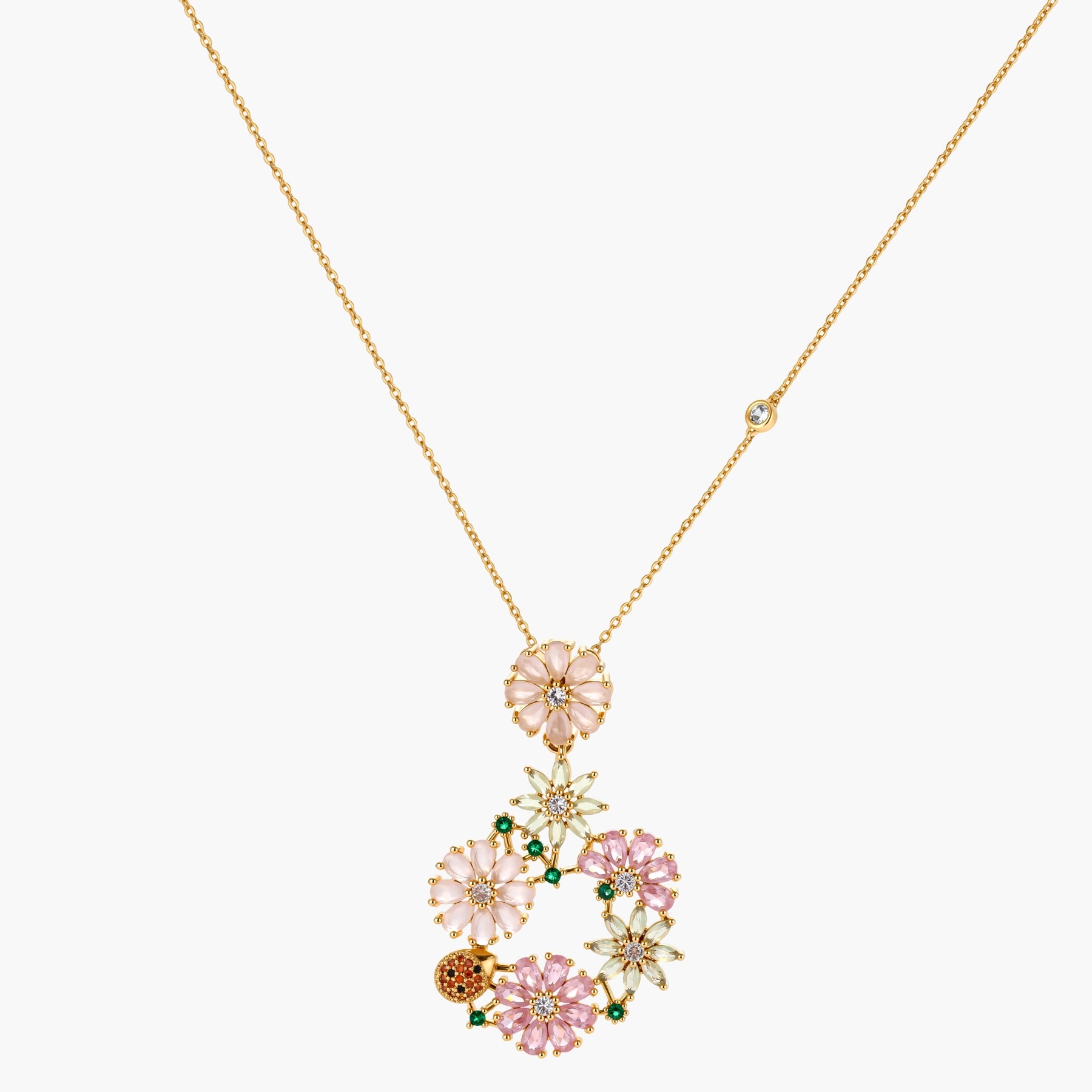 14K gold plated jewelry set with pink and green cubic zirconia flowers arranged in wreath design on cream background